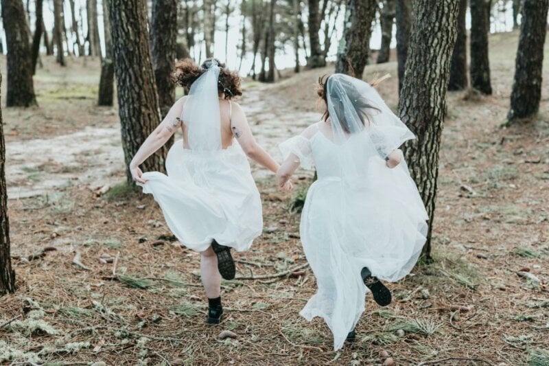 Couple de mariées en train de courir dans la forêt