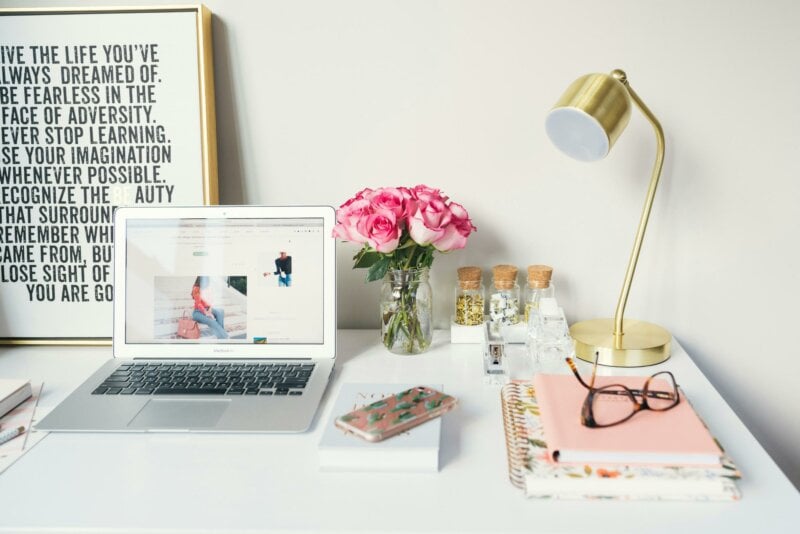 Ordinateur portable sur une table avec des fleurs et une lampe