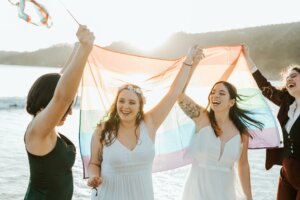 Couple de mariées et témoins avec un drapeau LGBTQ