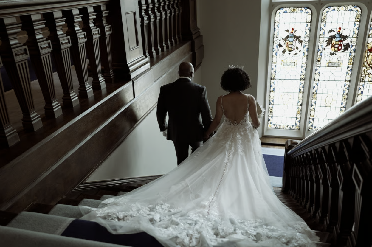 Father of the bride and bride walking down steps towards the ceremony