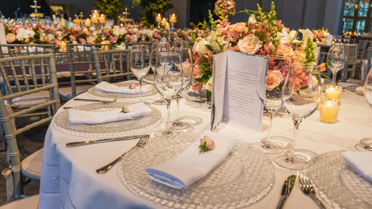 Wedding breakfast scene with napkins, crockery and cutlery on a roundtable decorated with flowers