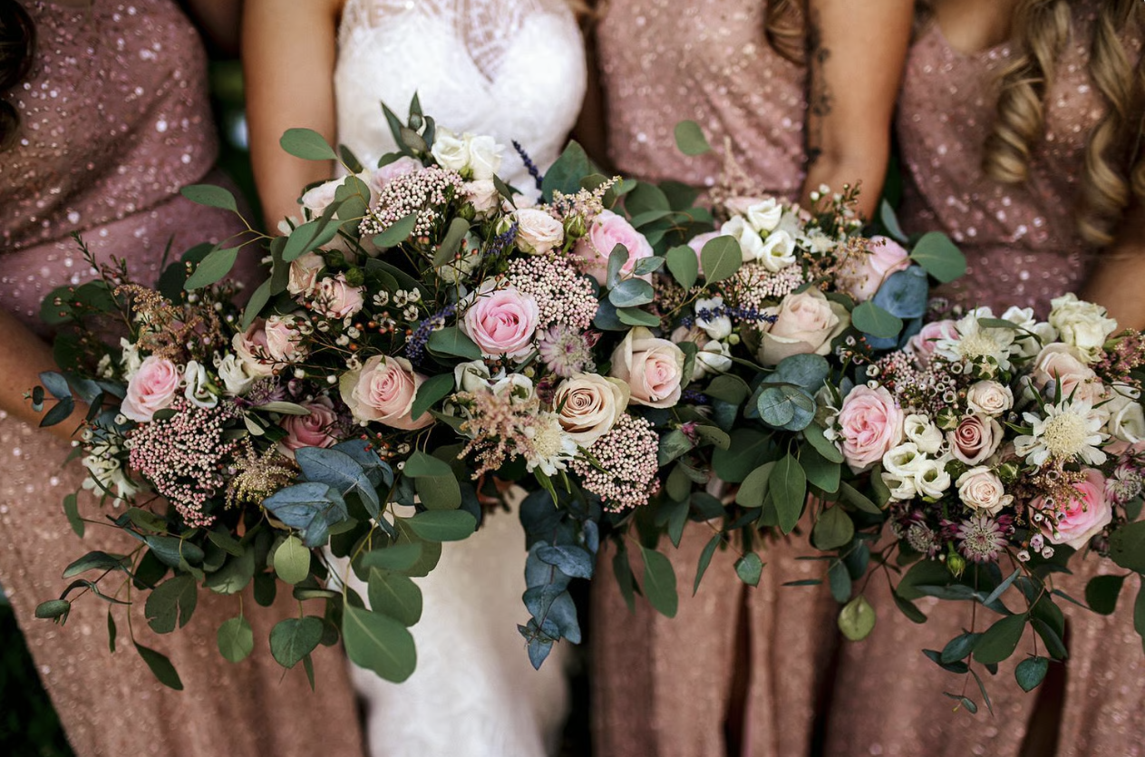 Bride and bridesmaids holding wedding bouquets 