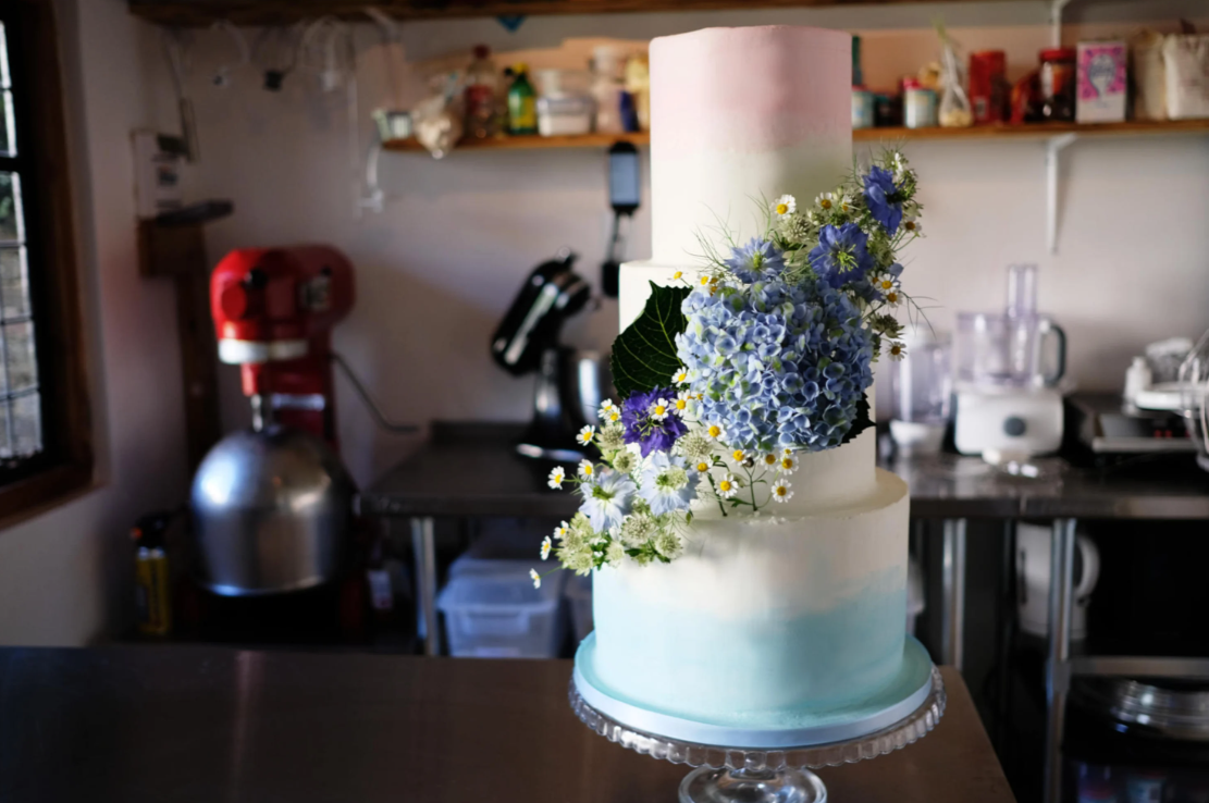 Gradient pink to blue wedding cake with floral decorations