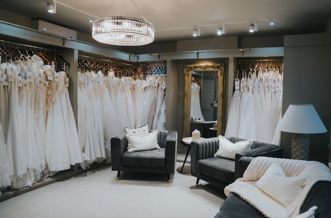 Inside a bridal boutique with rows of white wedding dresses waiting to be taken home