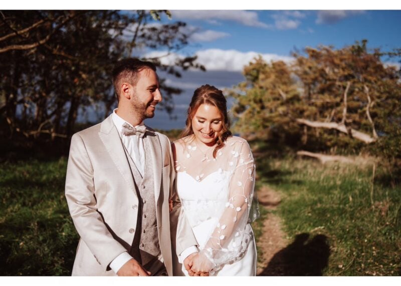 Glückliches frisch verheiratetes Ehepaar in der Natur, im Hintergrund Bäume