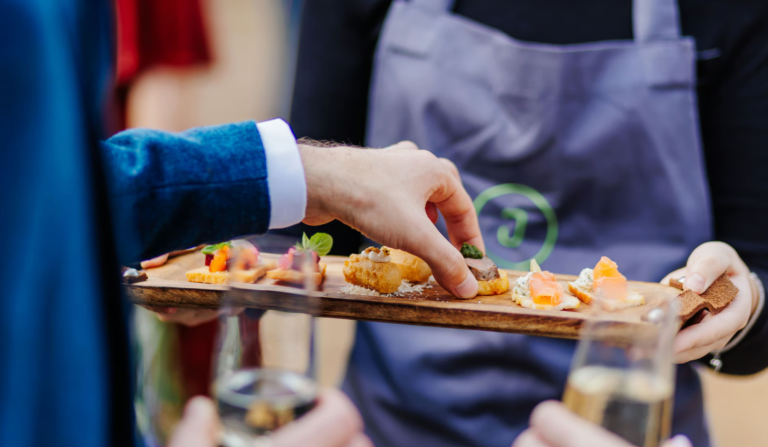 close up shot of a hand grabbing a canape off a tray at a wedding