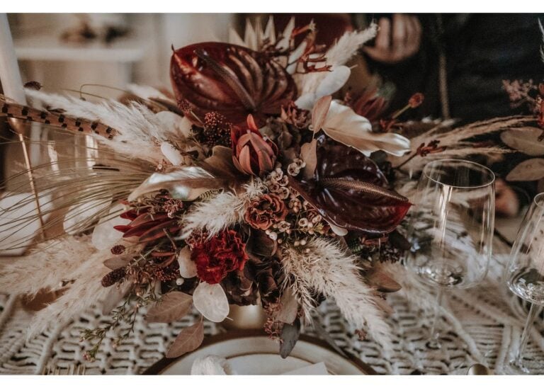 Tischdeko für eine Herbsthochzeit mit Blumenarrangement in Bordeaux, Trockenblumen und Pampasgras