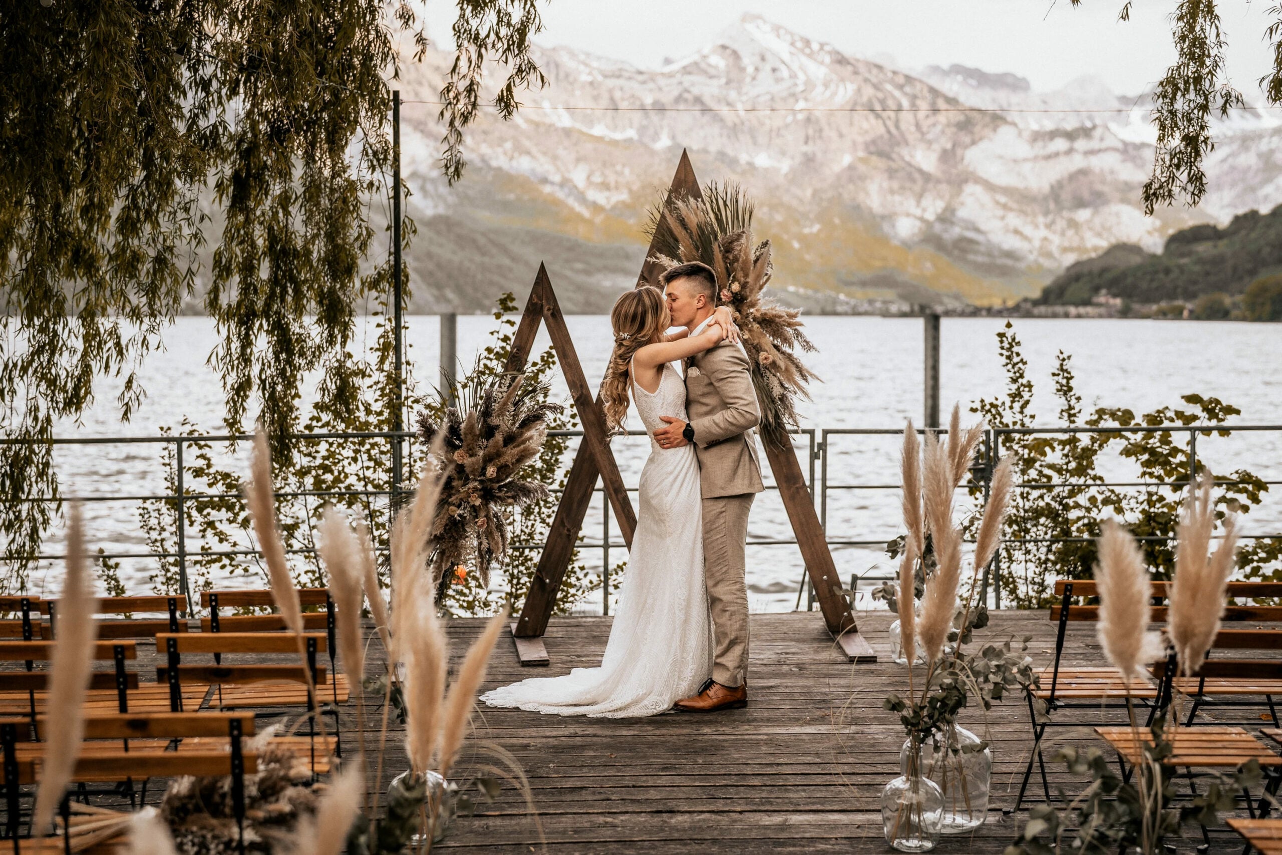 Hochzeitspaar küsst sich vor See