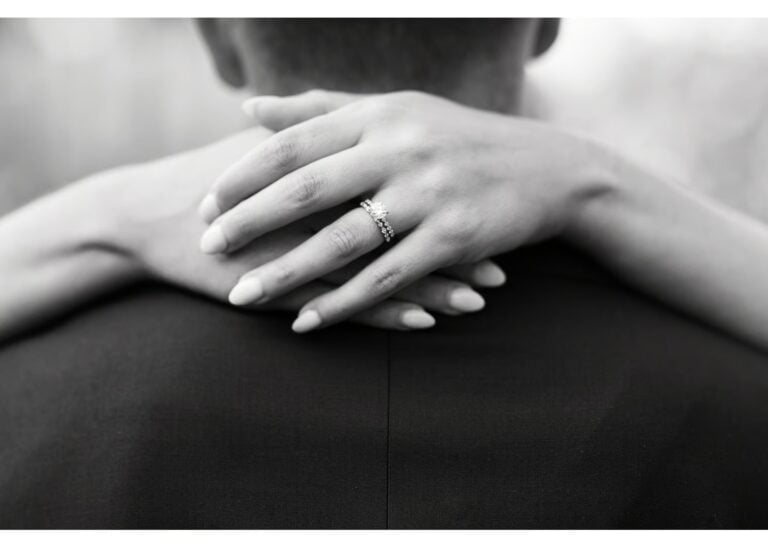 Detailaufnahme eines Verlobungsrings mit Diamant am Finger der Braut in Schwarz-weiß
