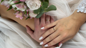 Detail shot of a man and woman's hand with wedding rings on ring finger