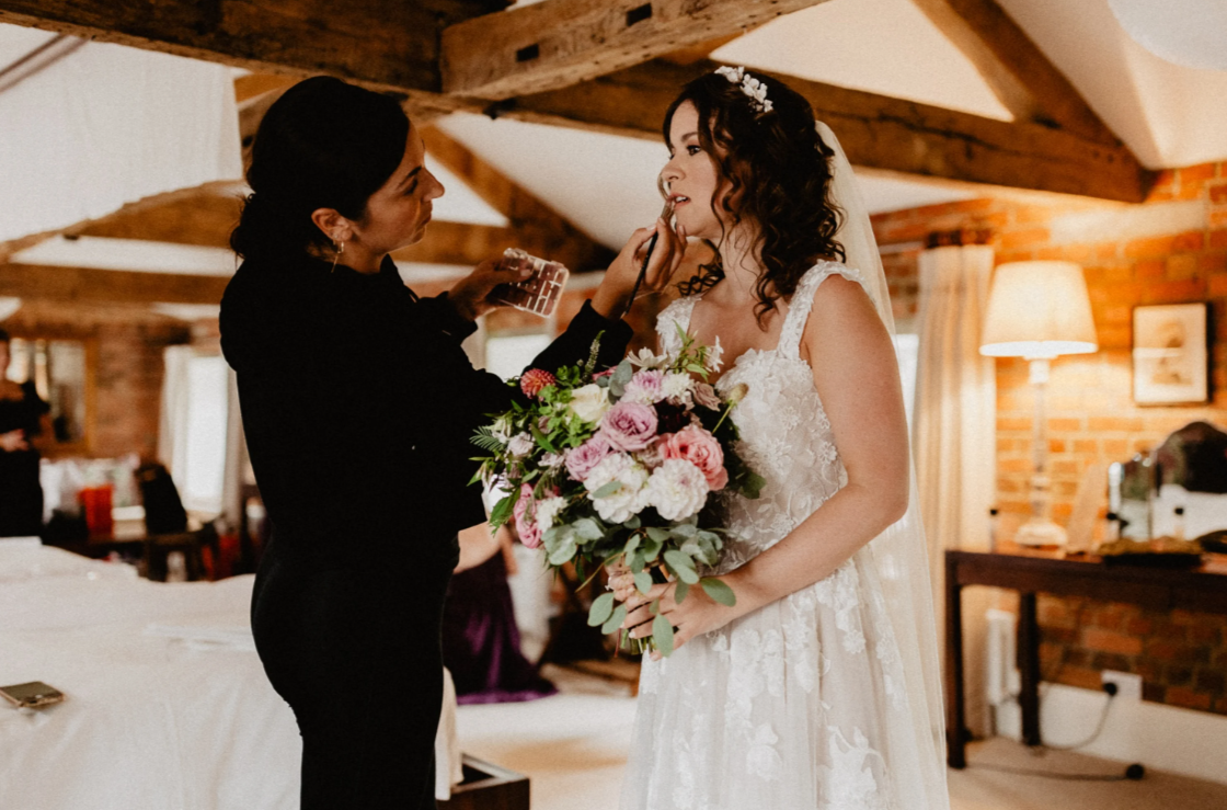 Makeup artist putting on makeup for the briide