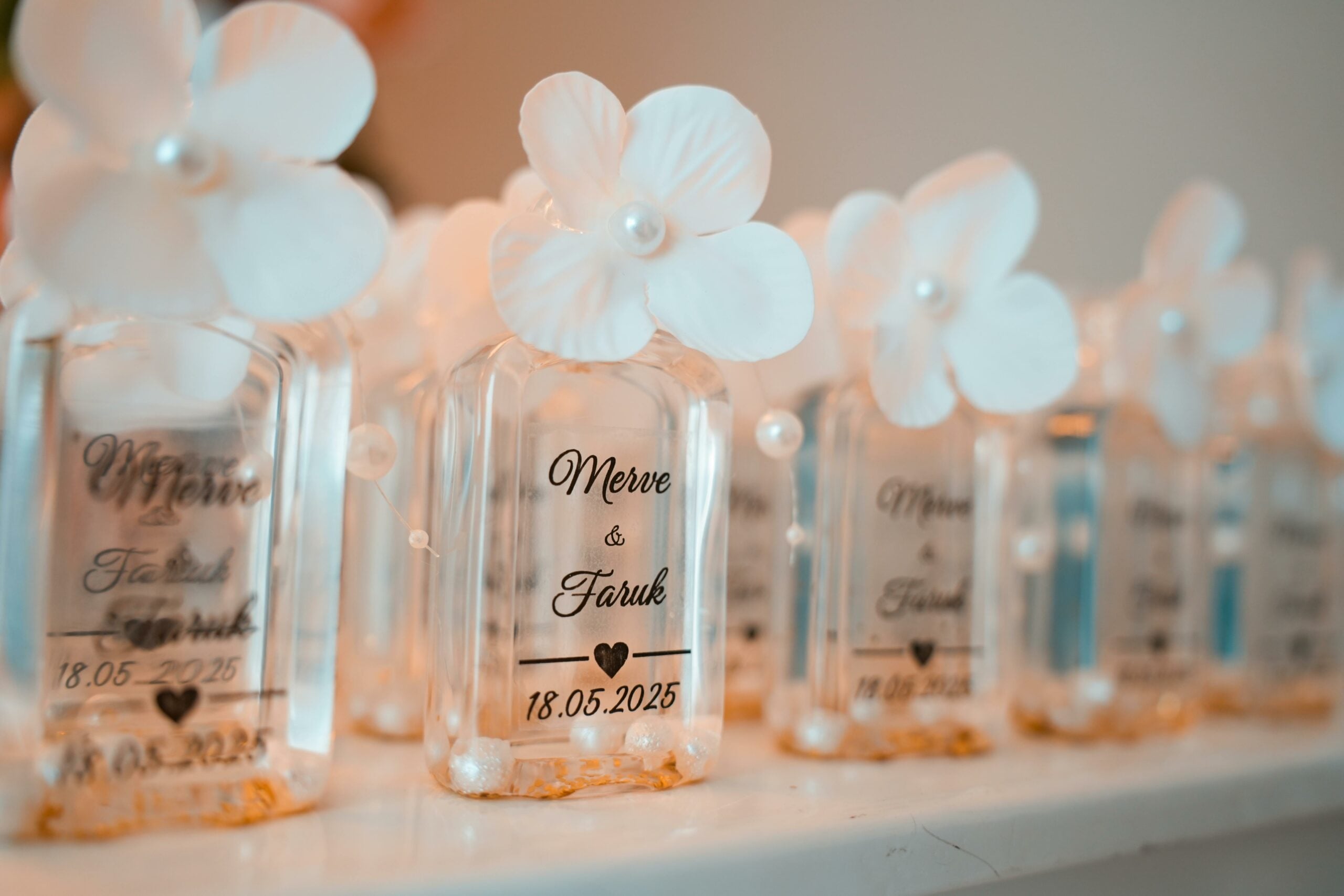 Small bottle of perfumes with names of newly wedded couple printed and date of ceremony