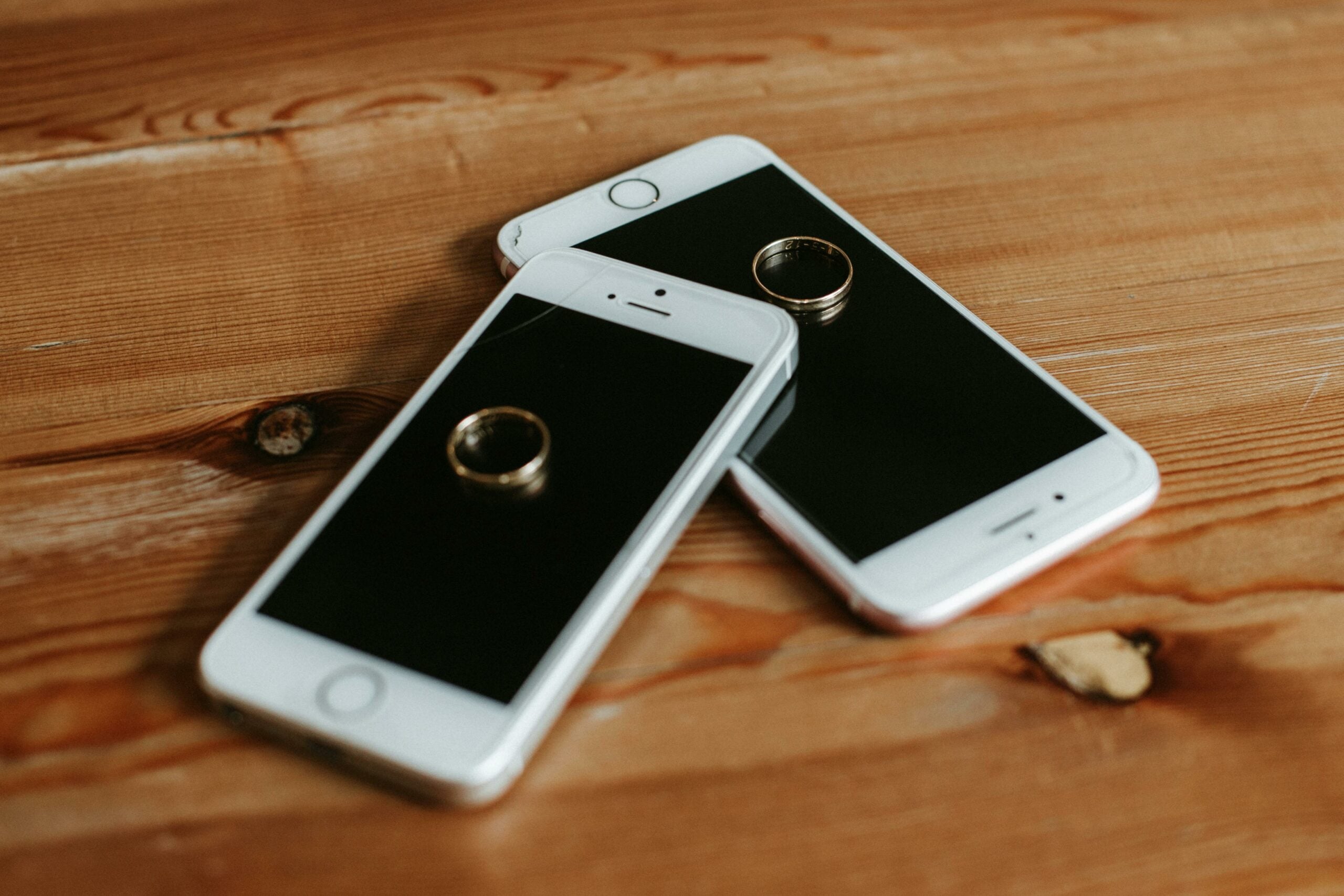 Wedding rings placed on two iphones