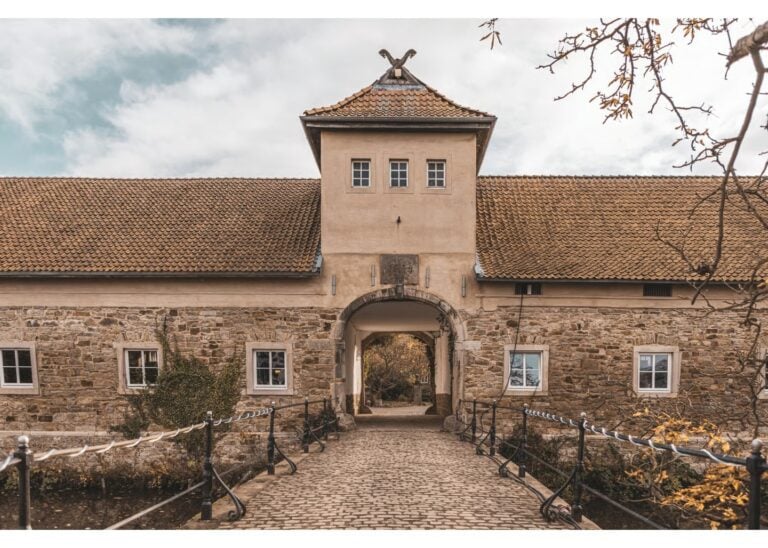 Historisches Torhaus aus Stein mit Durchgang und gepflastertem Weg