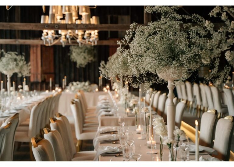 Elegant gedeckte Hochzeitstafel mit Kerzen und großen Blumenarrangements