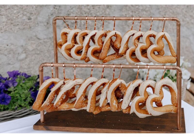 Kreative Hochzeit Food Idee mit hängenden Laugenbrezeln auf rustikalem Ständer