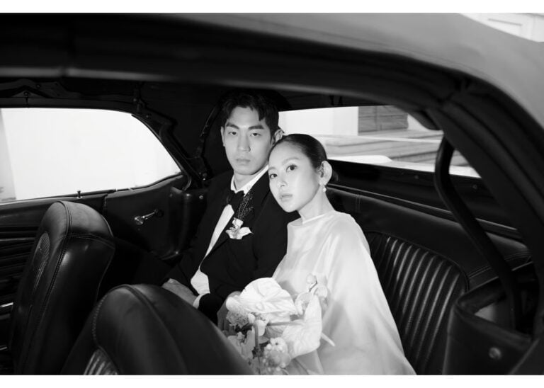 Braut und Bräutigam sitzen gemeinsam auf der Rückbank eines Autos