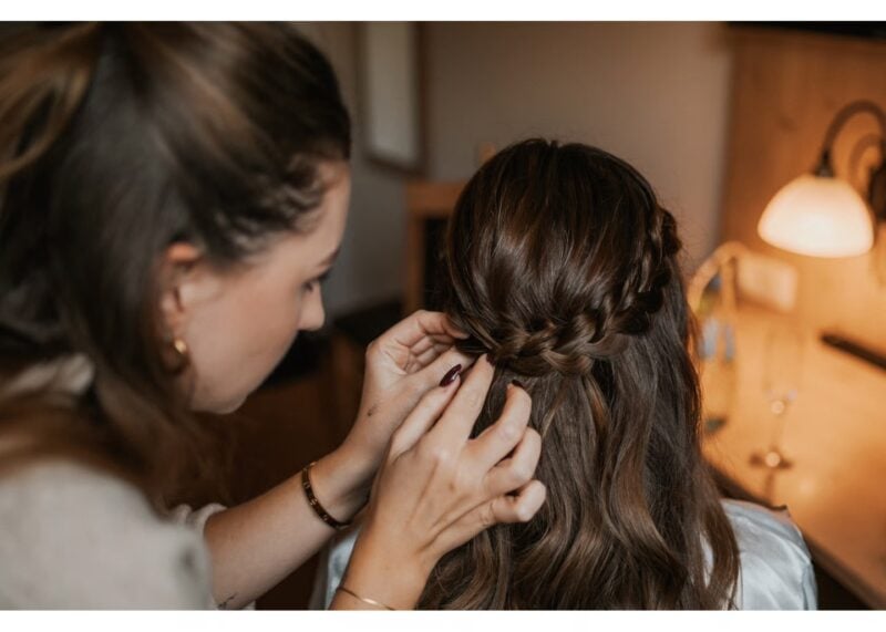 Halboffene Brautfrisur mit Flechtelementen beim Styling vor der Hochzeit