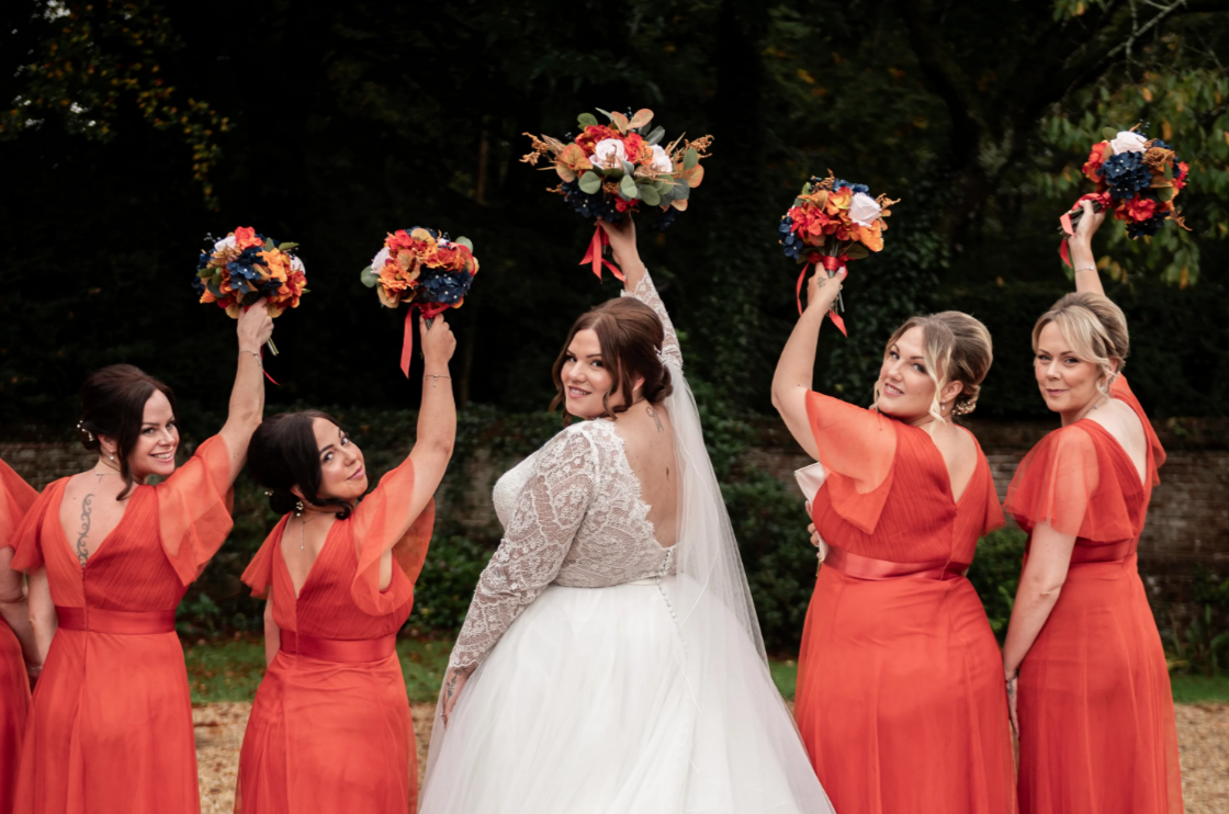 Bride and bridesmaids holding artificial flower bouquet
