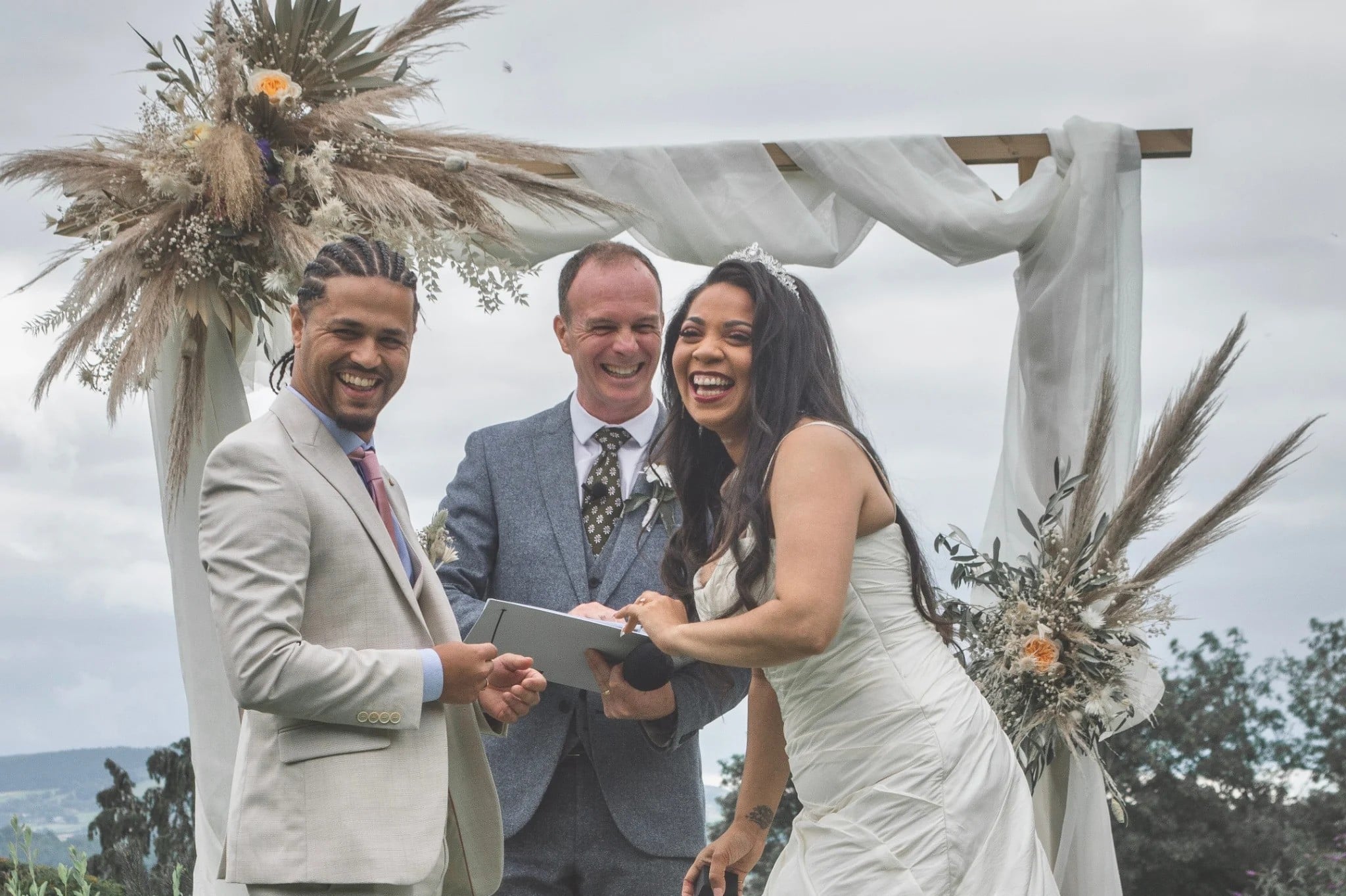 A wedding celebrant overseeing a wedding ceremony outdoors