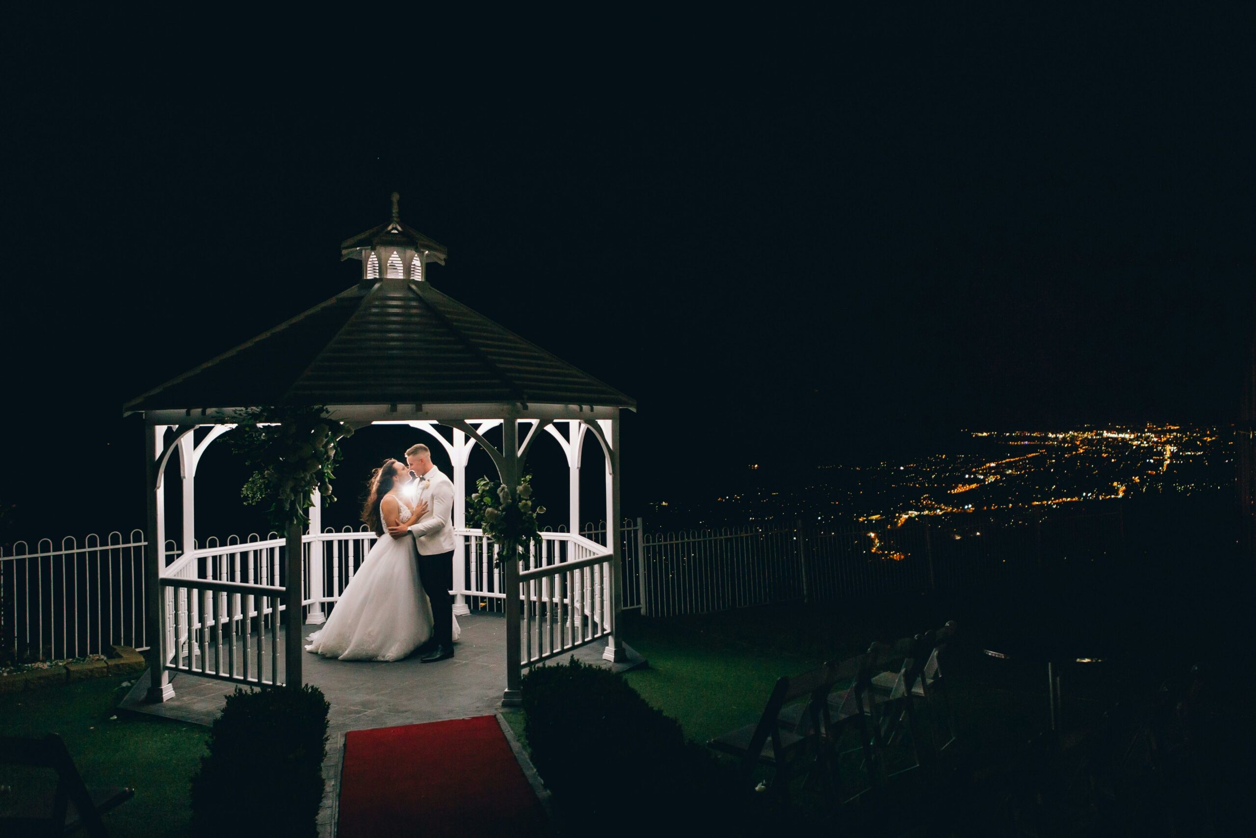 Kiwi bride and groom kissing under a pagoda at a destination wedding