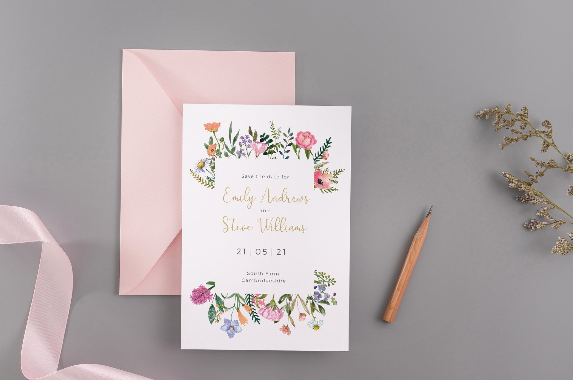 a white card wedding invitation with floral motif and complementing pink envelope