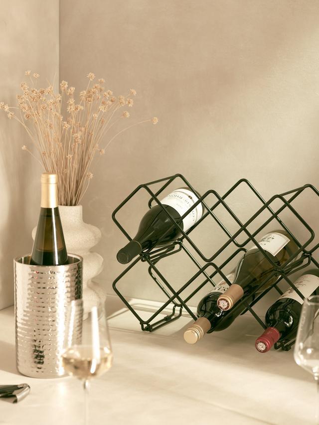 Stainless steel silver coloured wine cooler next to a wine rack