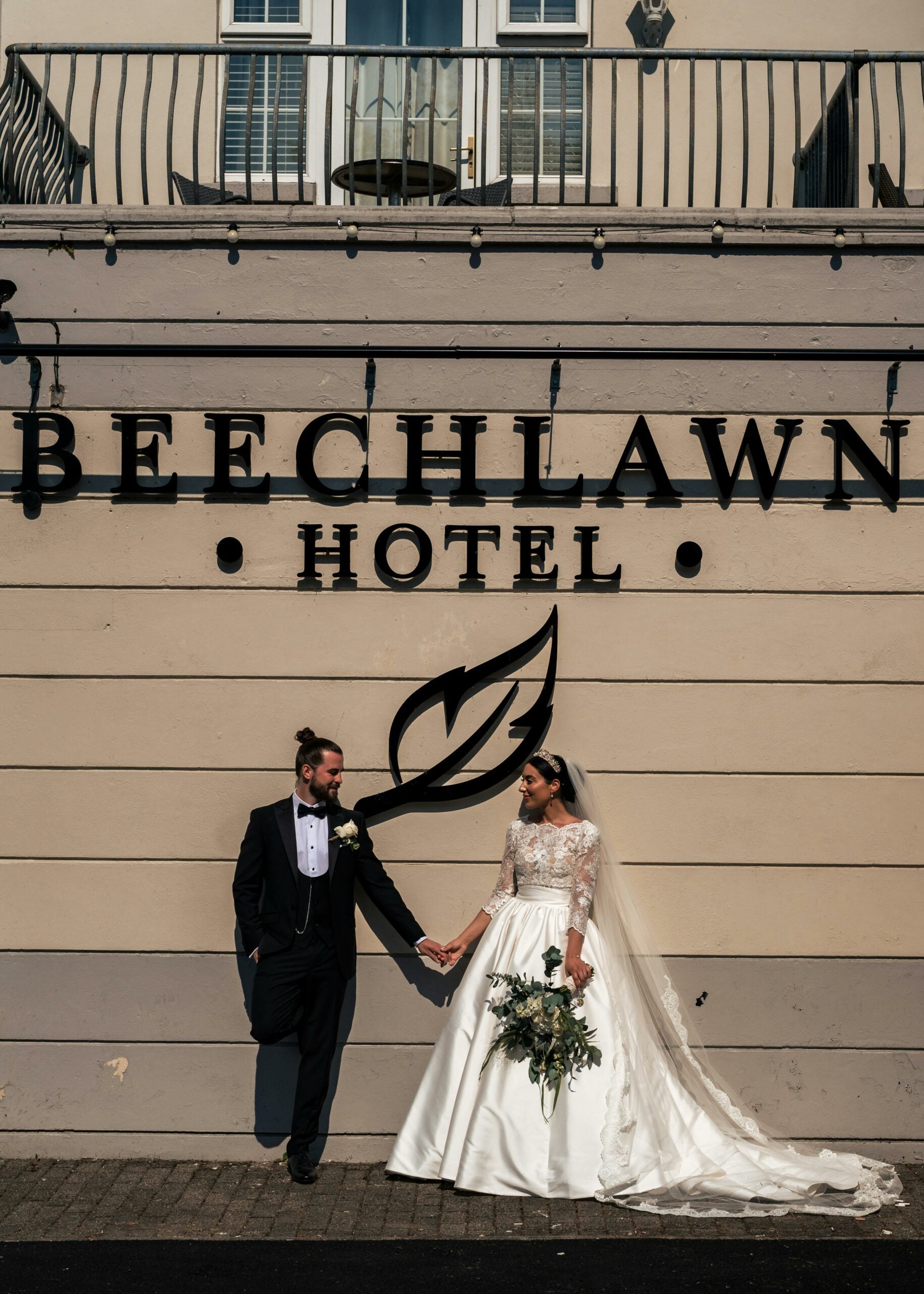 Bride and groom hand in hand outside of an irish hotel wedding venue