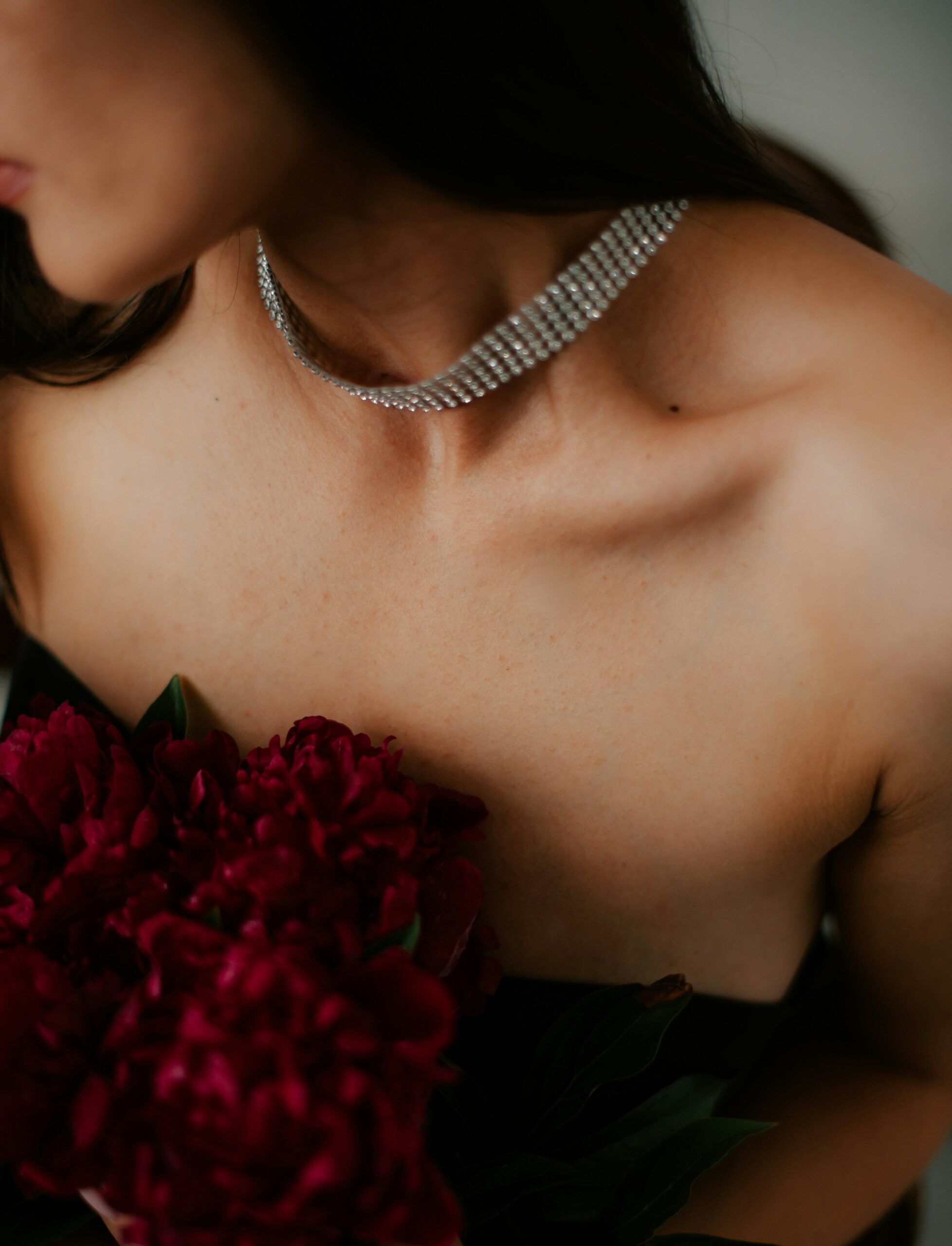 close up of a bride in a diamante choker with red roses
