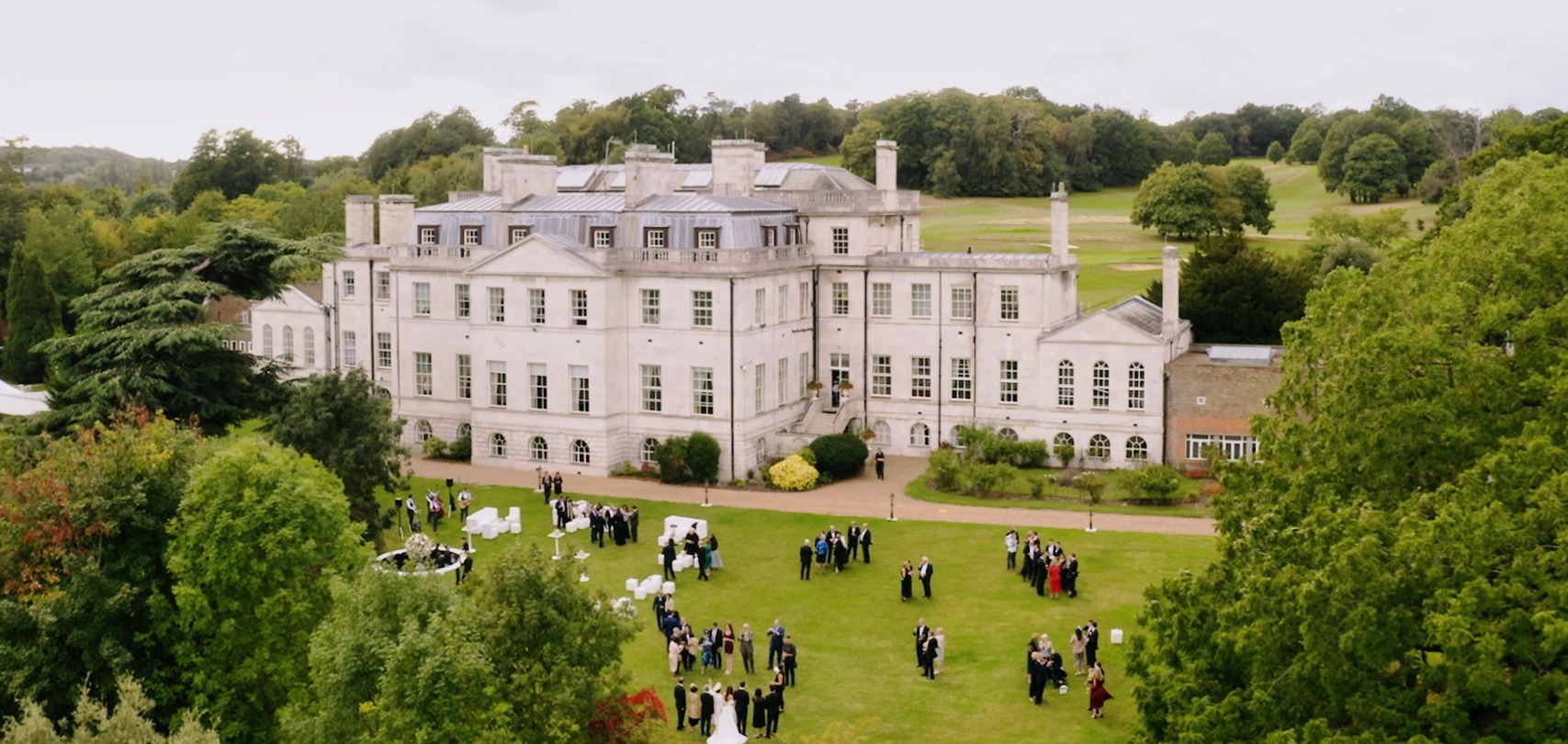 Outside shot of Addington Palace with wedding guests outside