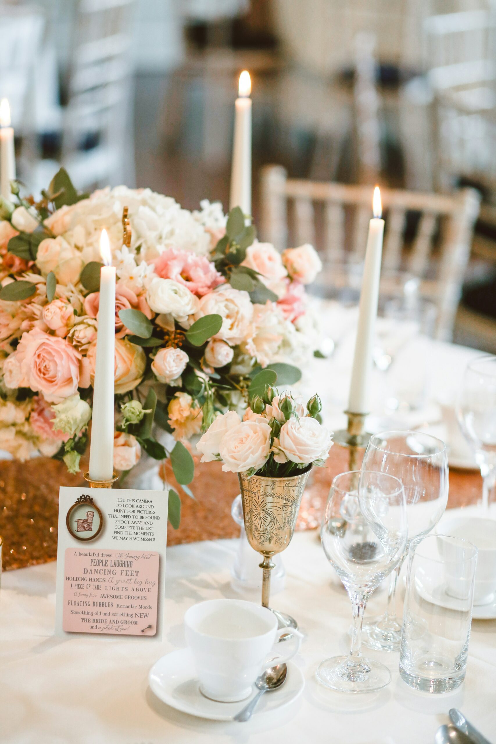 Close up of a floral wedding table centrepiece with tall tapered candles