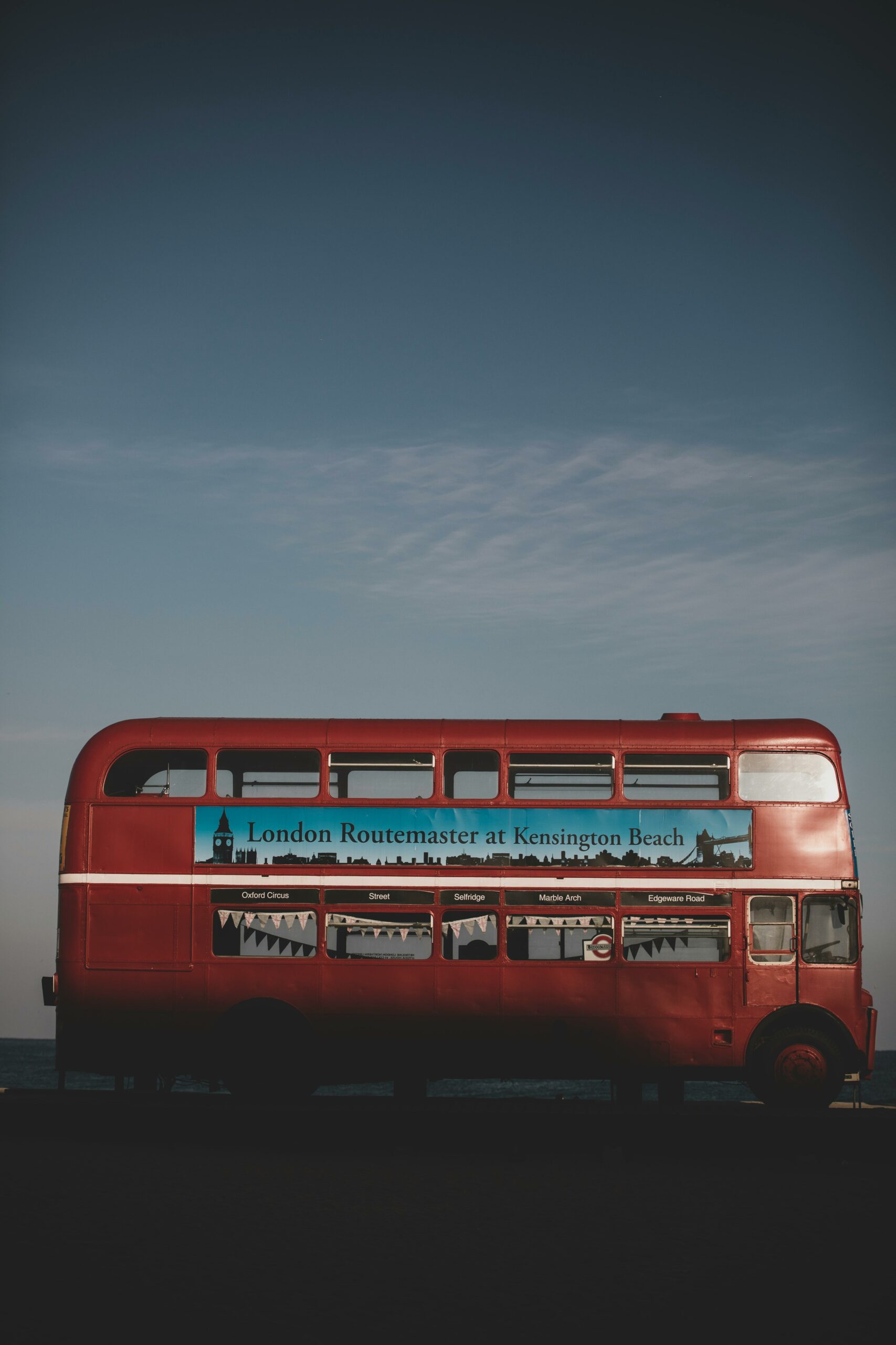 A red London bus decorated with bunting for a wedding