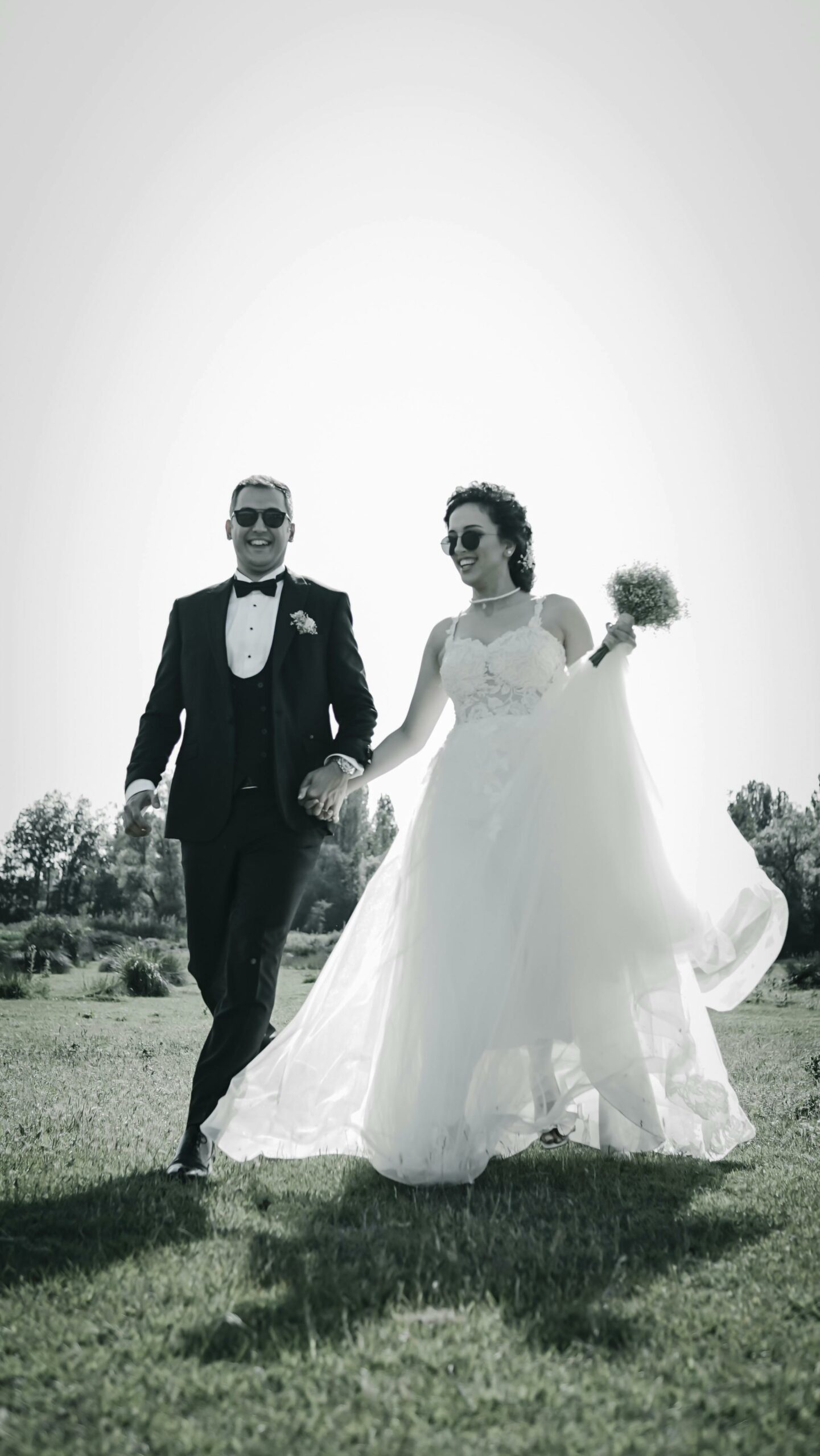 Bride and groom hand in hand in sunglasses at their New Zealand wedding