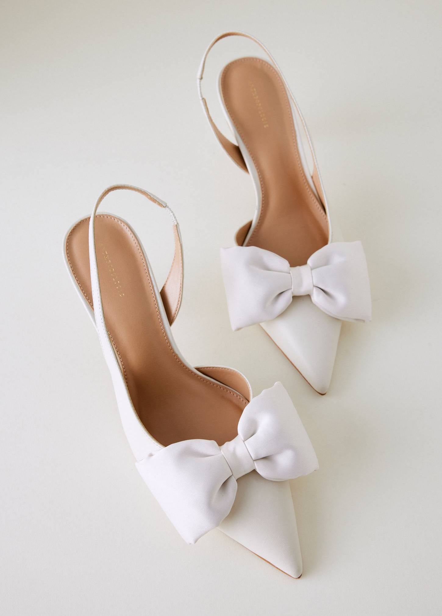 a pair of ivory coloured slingback stilettos with bow detail