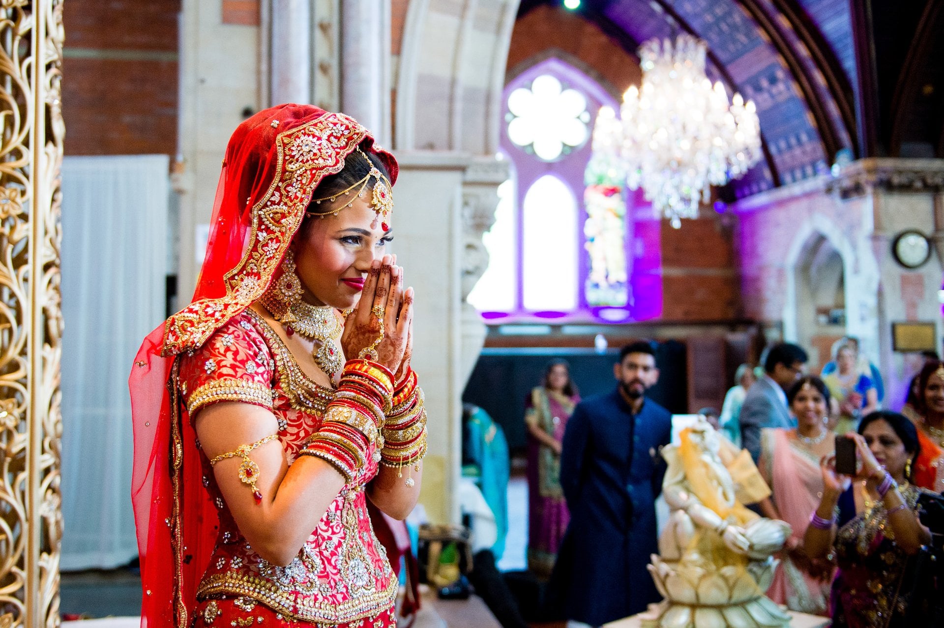 a hindu bride looking emotional and smiling as she listens to a wedding poem