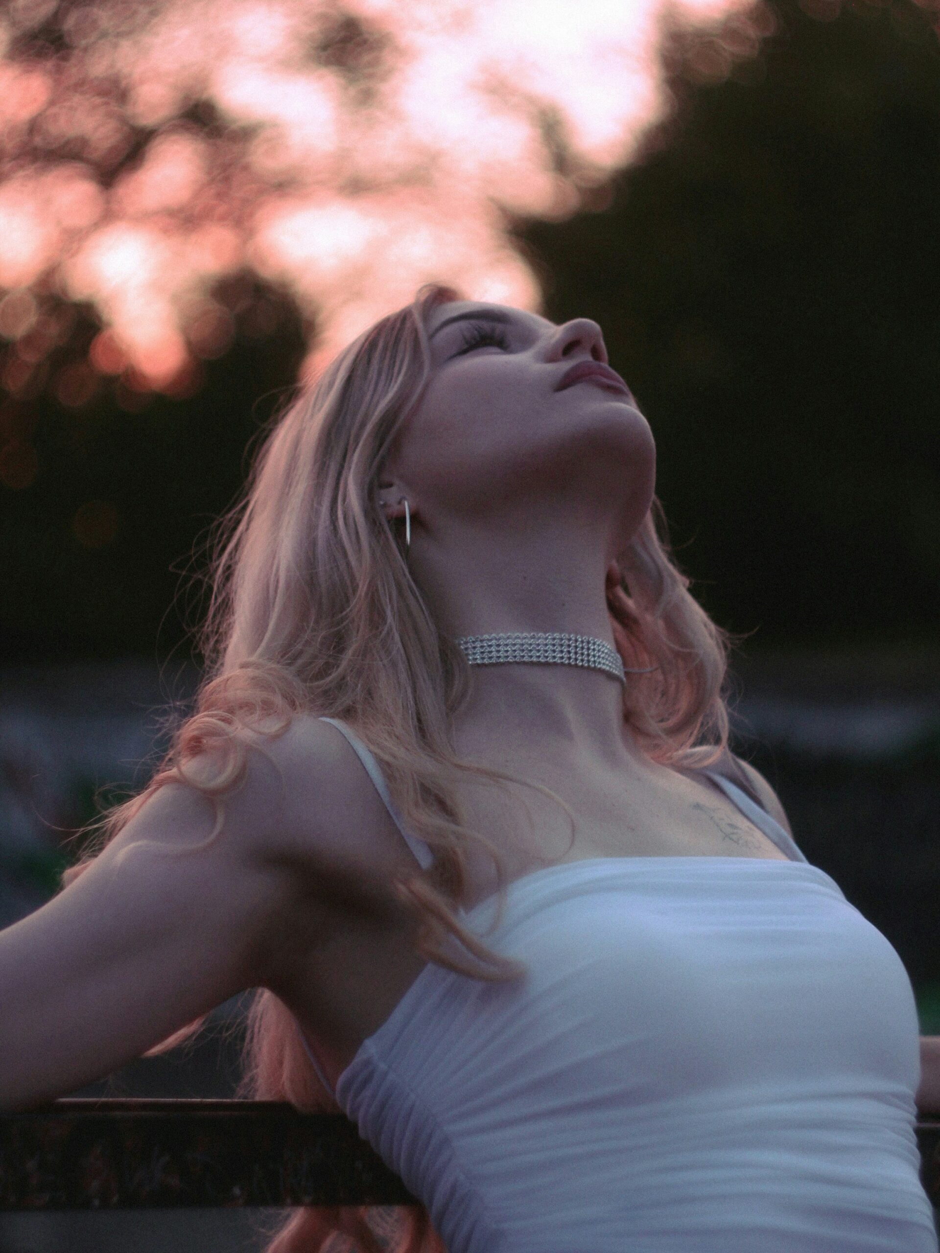 bride in a strapless wedding dress and a bridal choker looking up at the sky
