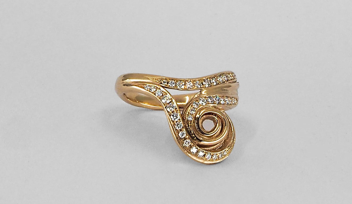 a sculptural pavé set engagement ring in yellow gold with small diamonds