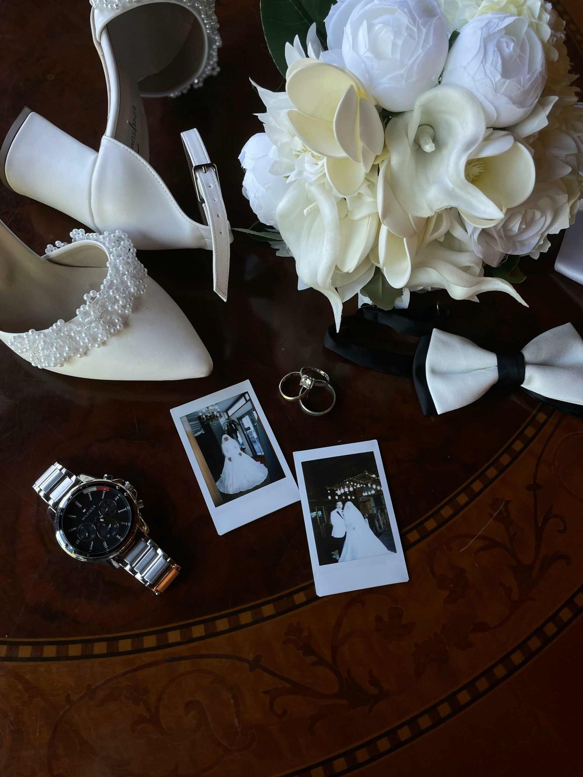 Styled flat lay with shoes, flowers, jewellery and wedding polaroids