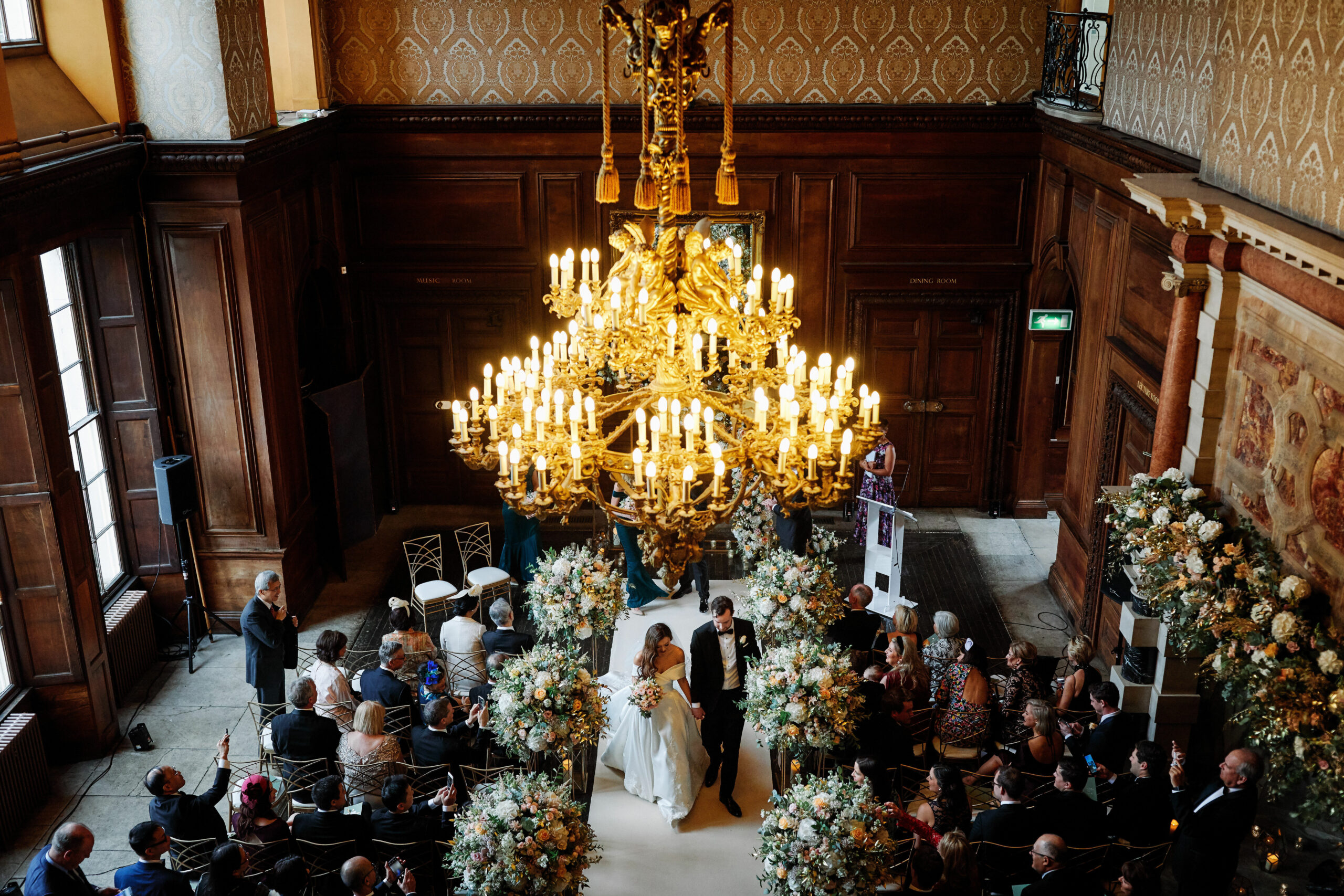 Newly wedded couple walking down the aisle after their ceremony inside Addington Palace