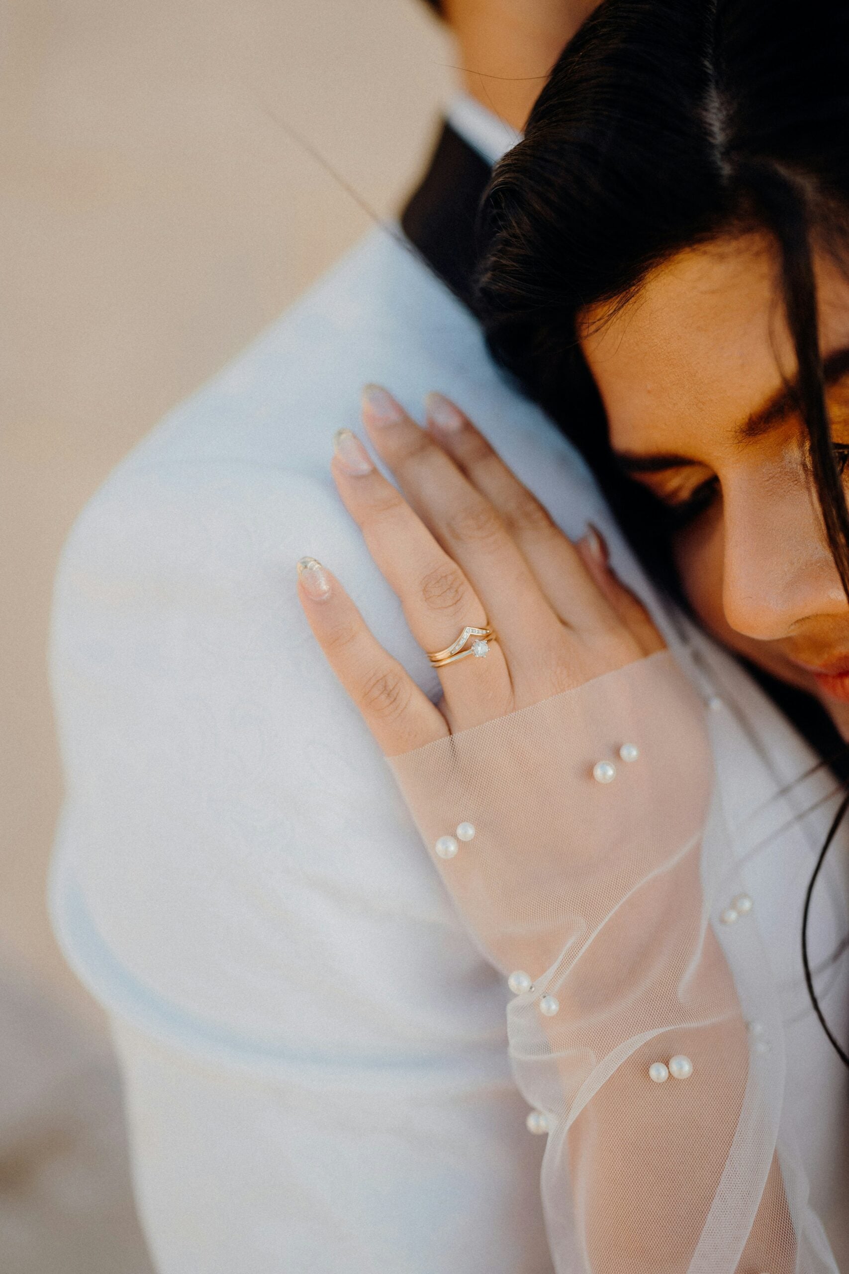 Bride wearing fingerless tulle gloves decorated with pearls