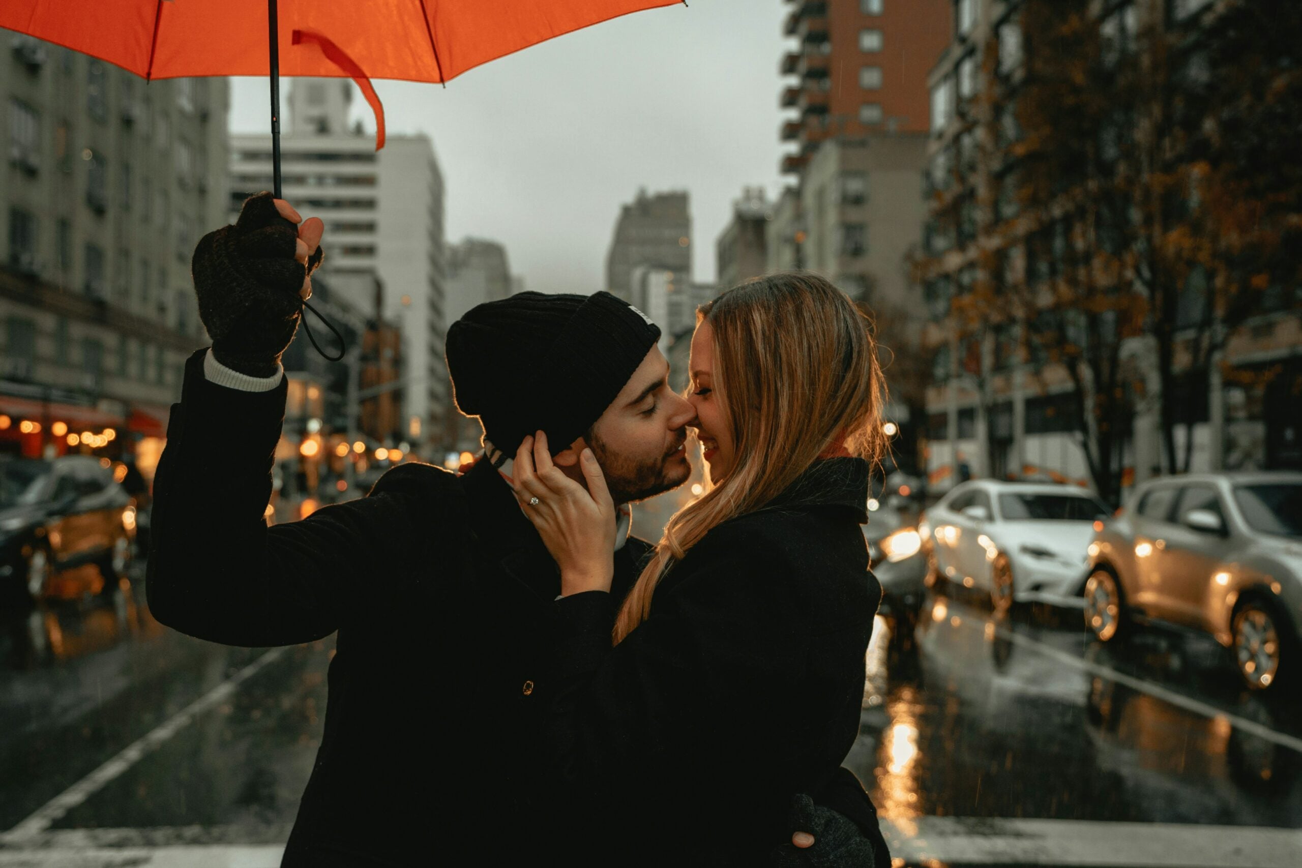 A newly married couple kissing in the rain on their honeymoon