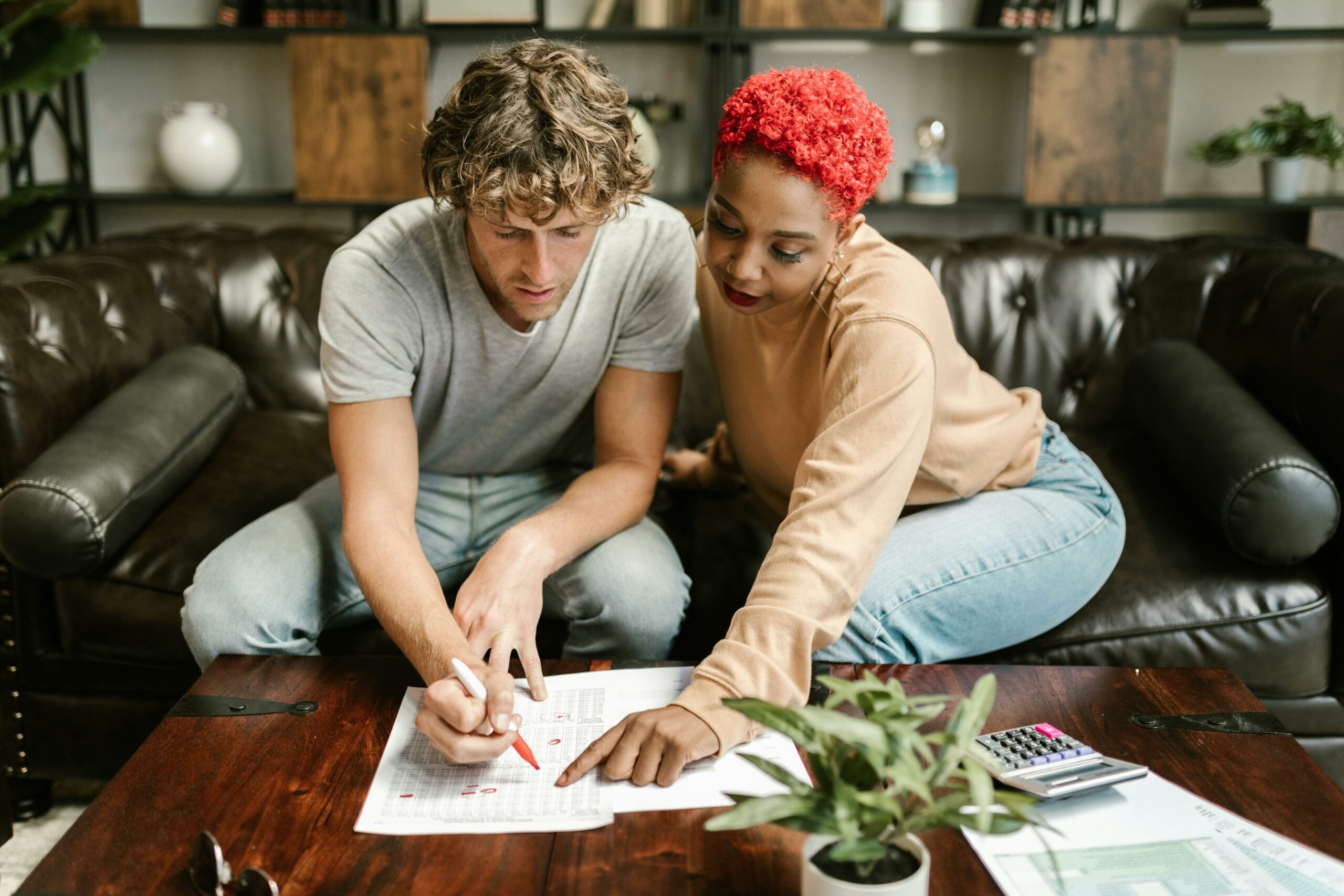 couple looking at documents on a coffee table together